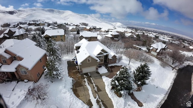 snowy aerial view with a residential view and a mountain view