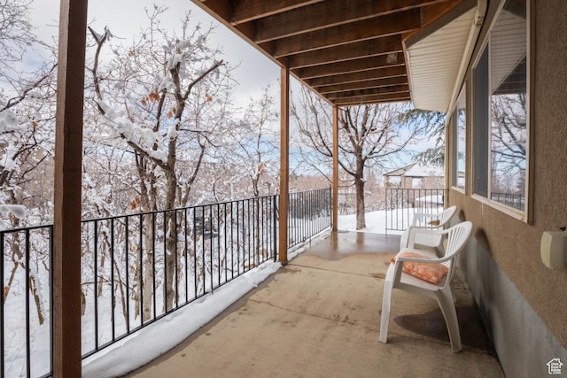 view of snow covered back of property