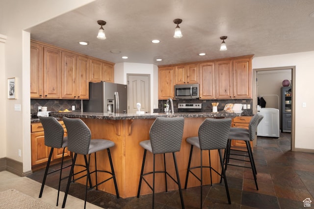 kitchen with tasteful backsplash, baseboards, an island with sink, stainless steel appliances, and recessed lighting
