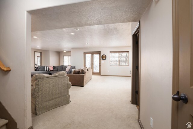 living room featuring recessed lighting, light carpet, a textured ceiling, and baseboards