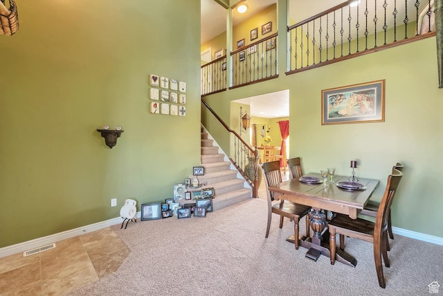 8783 N Franklin Dr, Eagle Mountain, UT 84005 - carpeted dining space with stairs, a towering ceiling, visible vents, and baseboards