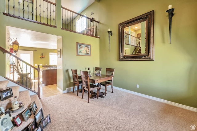 8783 N Franklin Dr, Eagle Mountain, UT 84005 - dining space with visible vents, a towering ceiling, stairway, light carpet, and baseboards