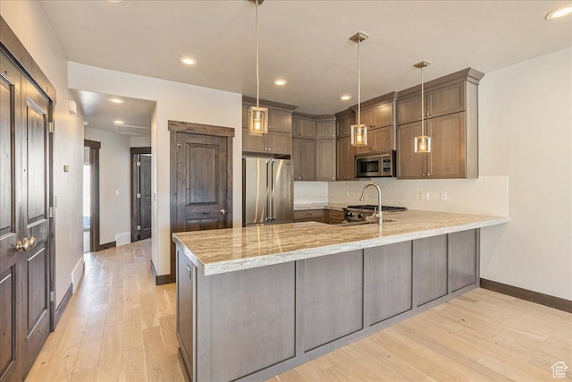 14408 N Buck Horn Trl N Unit 52C, Kamas, UT 84036 - kitchen with hanging light fixtures, light wood-type flooring, a peninsula, and appliances with stainless steel finishes