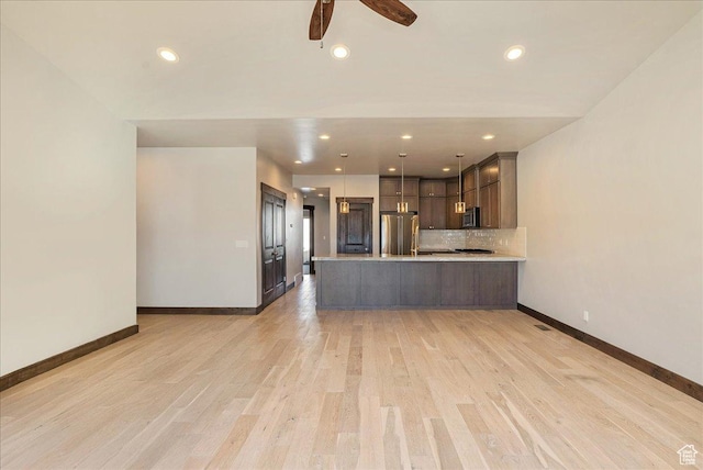 14408 N Buck Horn Trl N Unit 52C, Kamas, UT 84036 - kitchen with light countertops, hanging light fixtures, appliances with stainless steel finishes, dark brown cabinets, and a peninsula