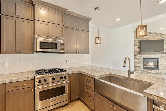 14408 N Buck Horn Trl N Unit 52C, Kamas, UT 84036 - kitchen with pendant lighting, tasteful backsplash, appliances with stainless steel finishes, a sink, and light stone countertops