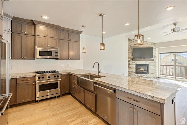 14408 N Buck Horn Trl N Unit 52C, Kamas, UT 84036 - kitchen featuring decorative light fixtures, appliances with stainless steel finishes, a sink, light stone countertops, and a peninsula