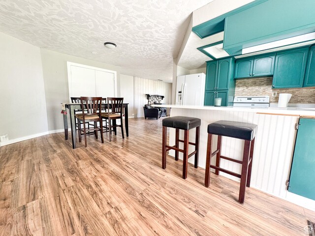 55 N 400 E, Heber City, UT 84032 - kitchen featuring blue cabinetry, range, white fridge with ice dispenser, light countertops, and a textured ceiling