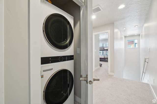 6698 Purple Poppy Ln Unit 11, Park City, UT 84098 - washroom with laundry area, visible vents, carpet flooring, a textured ceiling, and stacked washing maching and dryer