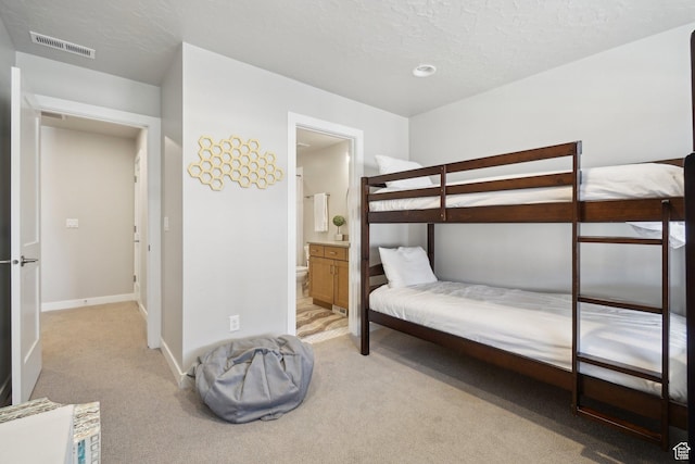 6698 Purple Poppy Ln Unit 11, Park City, UT 84098 - bedroom with light carpet, baseboards, visible vents, ensuite bathroom, and a textured ceiling