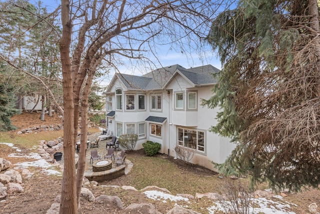 34 N Scenic Hills Cir E, North Salt Lake, UT 84054 - view of front of home with stucco siding, a shingled roof, an outdoor fire pit, and a patio