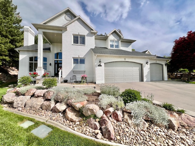 34 N Scenic Hills Cir E, North Salt Lake, UT 84054 - view of front of house with driveway, brick siding, an attached garage, and a chimney