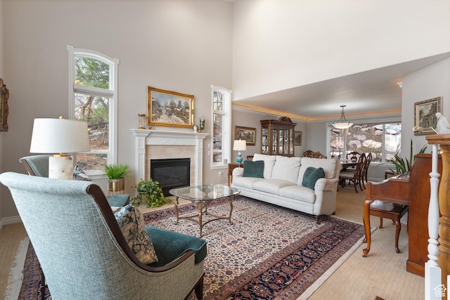 34 N Scenic Hills Cir E, North Salt Lake, UT 84054 - living room featuring a glass covered fireplace, a towering ceiling, carpet floors, and crown molding