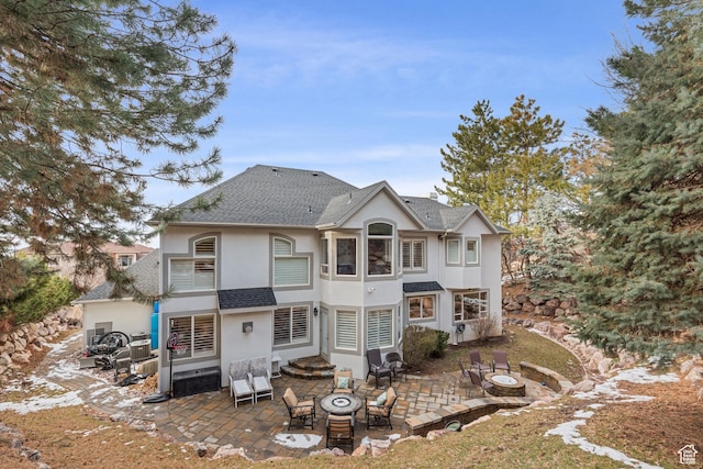 34 N Scenic Hills Cir E, North Salt Lake, UT 84054 - back of property with an outdoor fire pit, a patio area, and stucco siding