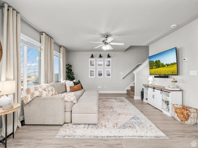 1463 S Lake View Terrace Rd, Saratoga Springs, UT 84045 - living room featuring a textured ceiling, light wood finished floors, stairway, and a ceiling fan