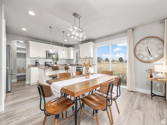 1463 S Lake View Terrace Rd, Saratoga Springs, UT 84045 - dining area with arched walkways, light wood finished floors, recessed lighting, and baseboards