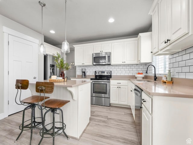 1463 S Lake View Terrace Rd, Saratoga Springs, UT 84045 - kitchen with a kitchen island, stainless steel appliances, light countertops, white cabinetry, and a sink