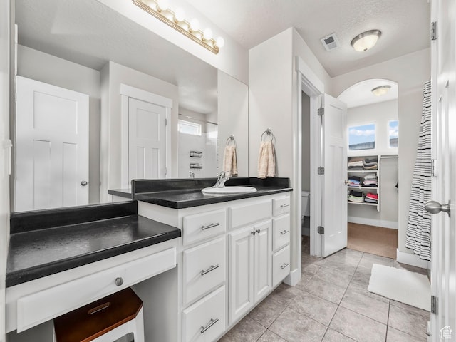 1463 S Lake View Terrace Rd, Saratoga Springs, UT 84045 - full bathroom featuring a walk in closet, visible vents, vanity, tile patterned flooring, and baseboards