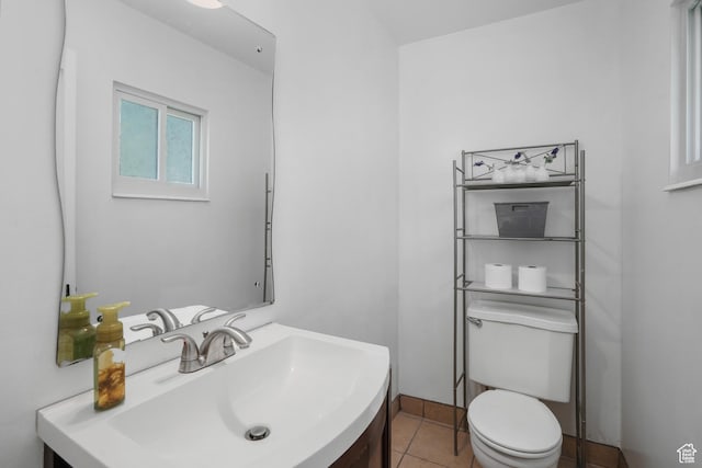 bathroom with toilet, a sink, and tile patterned floors