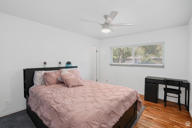 bedroom featuring light wood-type flooring, a ceiling fan, and baseboards