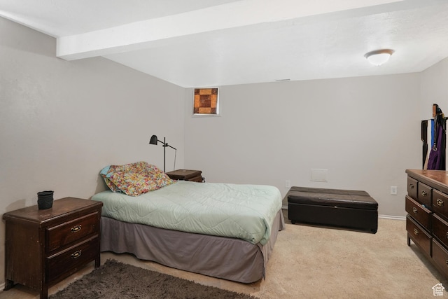 bedroom featuring baseboards, beam ceiling, and light colored carpet