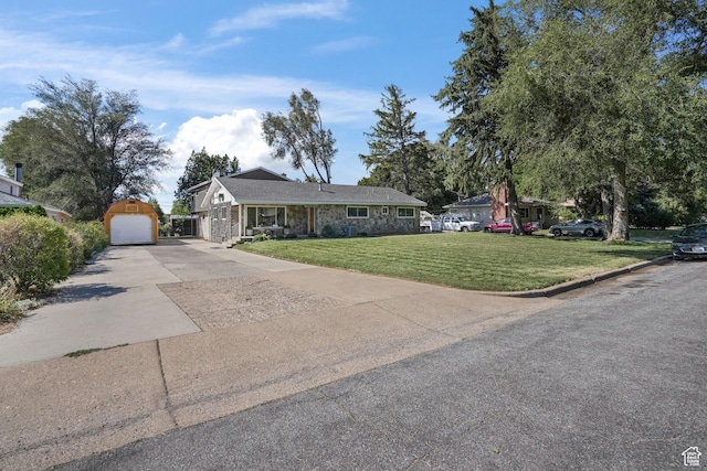 ranch-style house with stone siding, a detached garage, concrete driveway, and a front yard