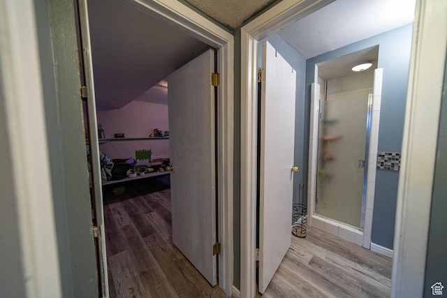 hall with light wood-style flooring and baseboards