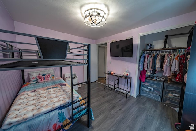 bedroom with a chandelier, a closet, and wood finished floors