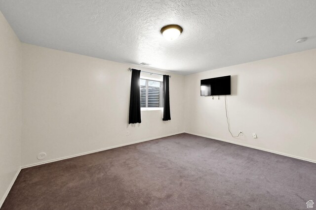 59 Belmore Dr, Kaysville, UT 84037 - spare room featuring a textured ceiling, dark carpet, visible vents, and baseboards