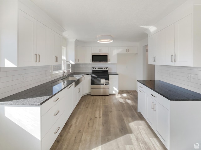 1439 W 1200 N, Layton, UT 84041 - kitchen with light wood finished floors, stainless steel appliances, a sink, backsplash, and white cabinetry