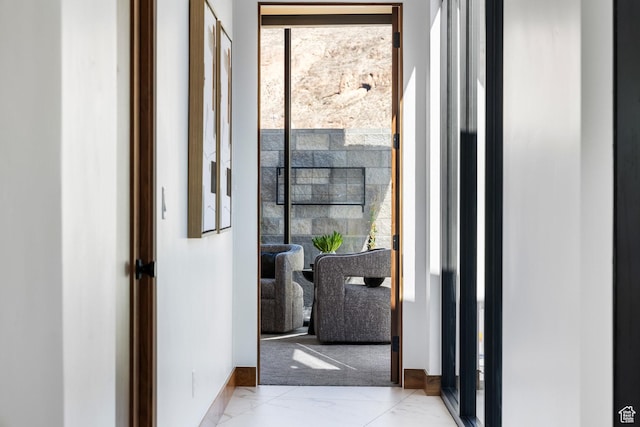 doorway to outside featuring marble finish floor