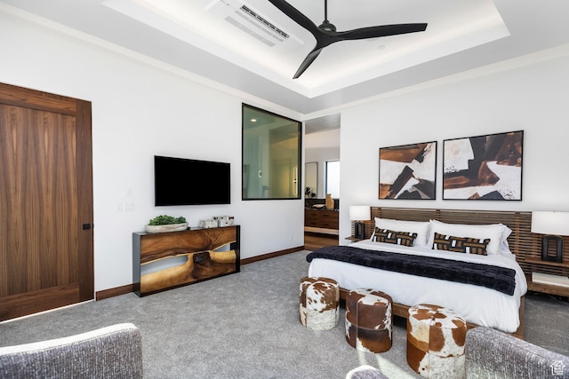 bedroom with carpet flooring, a raised ceiling, visible vents, and baseboards