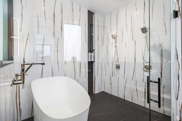 bathroom featuring a marble finish shower, a freestanding tub, and tile walls