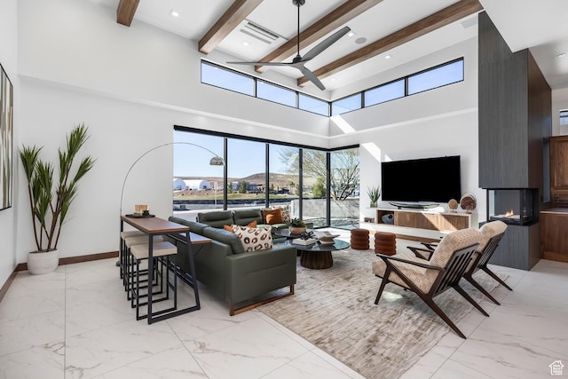 living area featuring marble finish floor, a large fireplace, and beamed ceiling