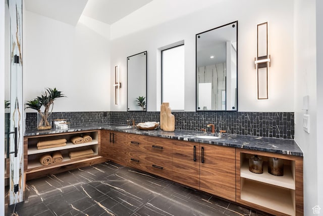 bathroom with tasteful backsplash, marble finish floor, a sink, and double vanity