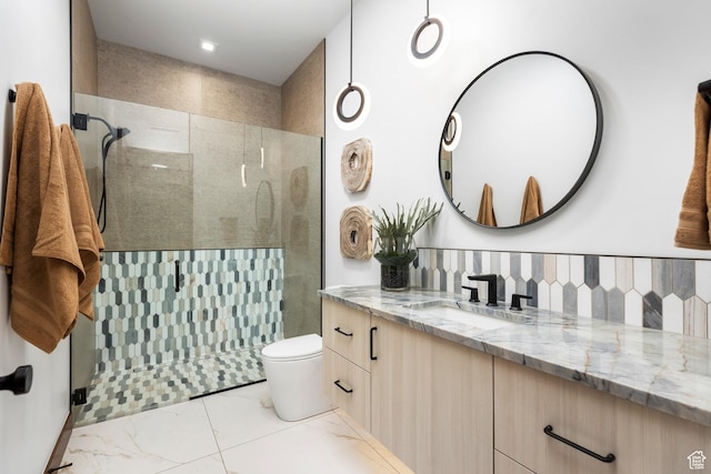 bathroom with toilet, tiled shower, and vanity