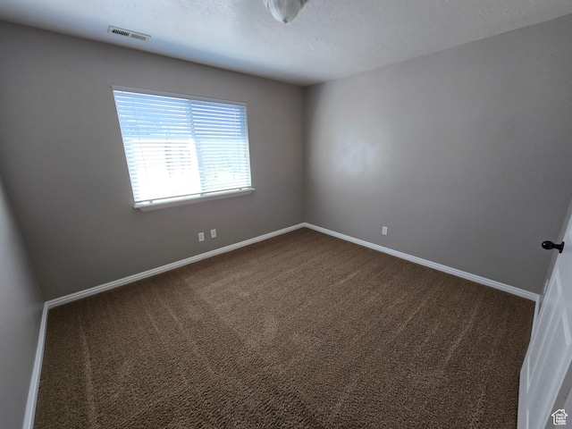 8204 N Cedar Springs Rd E Unit U-12, Eagle Mountain, UT 84005 - spare room featuring visible vents, baseboards, dark carpet, and a textured ceiling