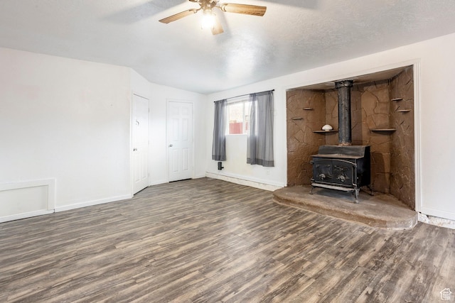 170 S 500 E, Duchesne, UT 84021 - unfurnished living room with a wood stove, ceiling fan, a textured ceiling, and dark wood-style flooring