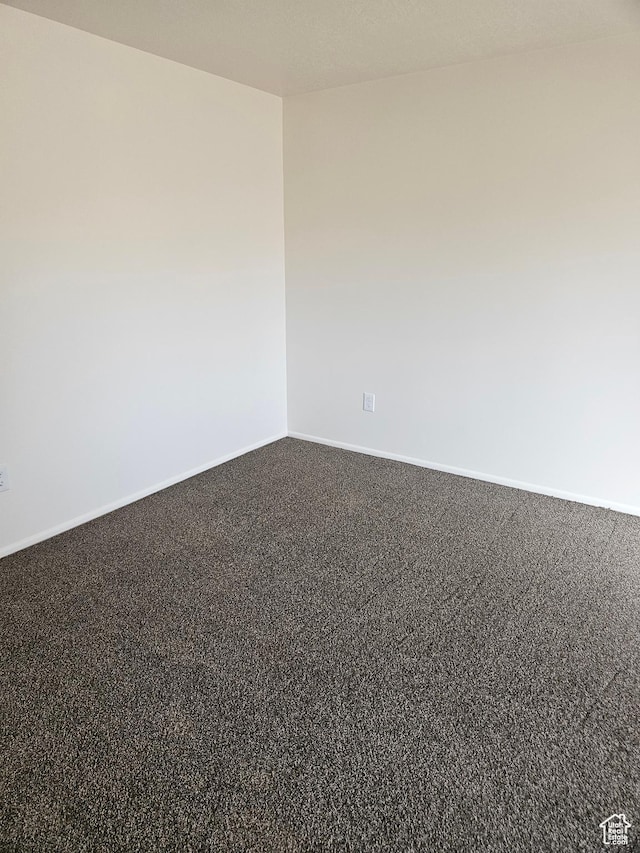 unfurnished room with carpet flooring and baseboards