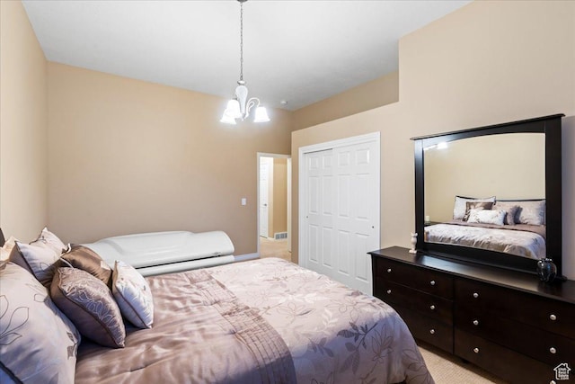 bedroom featuring a chandelier, a closet, and light colored carpet