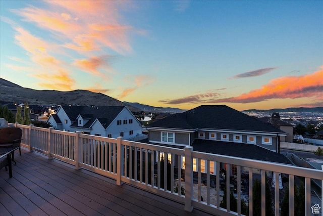 deck at dusk featuring a residential view and a mountain view