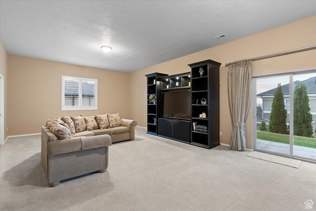 carpeted living area featuring a textured ceiling, visible vents, and baseboards