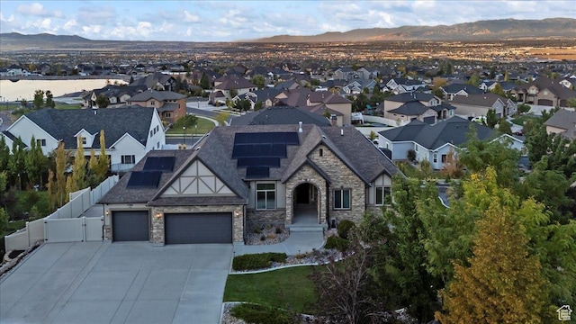 view of front of property featuring an attached garage, a residential view, and a mountain view