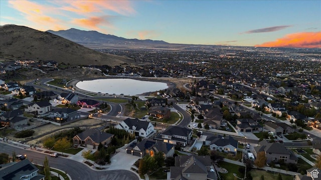 aerial view at dusk with a residential view and a water and mountain view