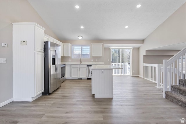 8475 S 1520 W, West Jordan, UT 84088 - kitchen featuring lofted ceiling, a center island, light countertops, stainless steel appliances, and a sink