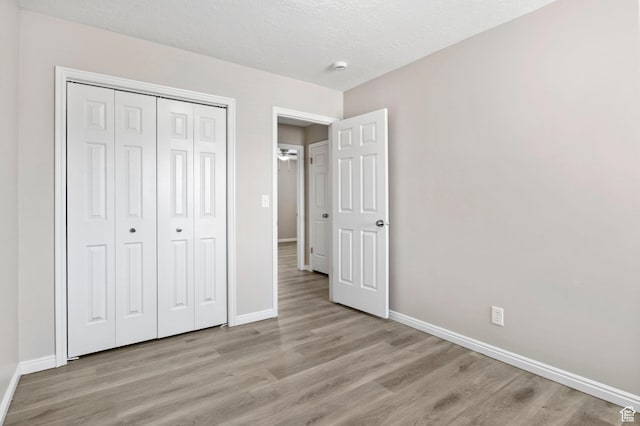 8475 S 1520 W, West Jordan, UT 84088 - unfurnished bedroom with light wood-style flooring, a textured ceiling, baseboards, and a closet