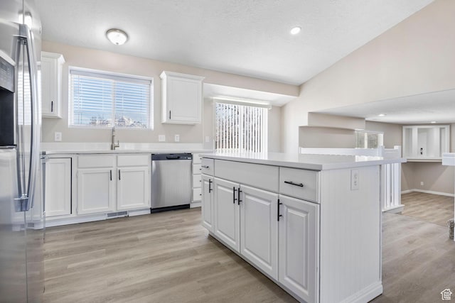8475 S 1520 W, West Jordan, UT 84088 - kitchen with stainless steel appliances, a sink, white cabinetry, light countertops, and a center island