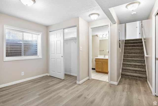8475 S 1520 W, West Jordan, UT 84088 - unfurnished bedroom featuring a closet, baseboards, a textured ceiling, and light wood finished floors