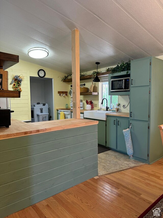 1526 N Dixie Downs Rd N 36, St George, UT 84770 - kitchen featuring open shelves, stainless steel microwave, a sink, and light wood-style flooring