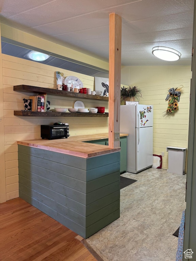 1526 N Dixie Downs Rd N 36, St George, UT 84770 - kitchen with open shelves, light wood-style flooring, wood walls, and freestanding refrigerator
