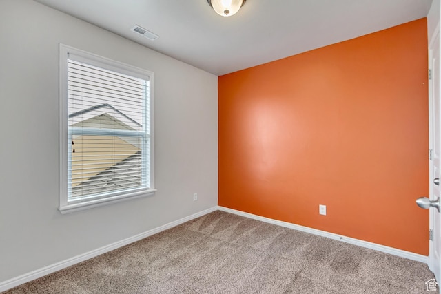carpeted empty room with visible vents and baseboards